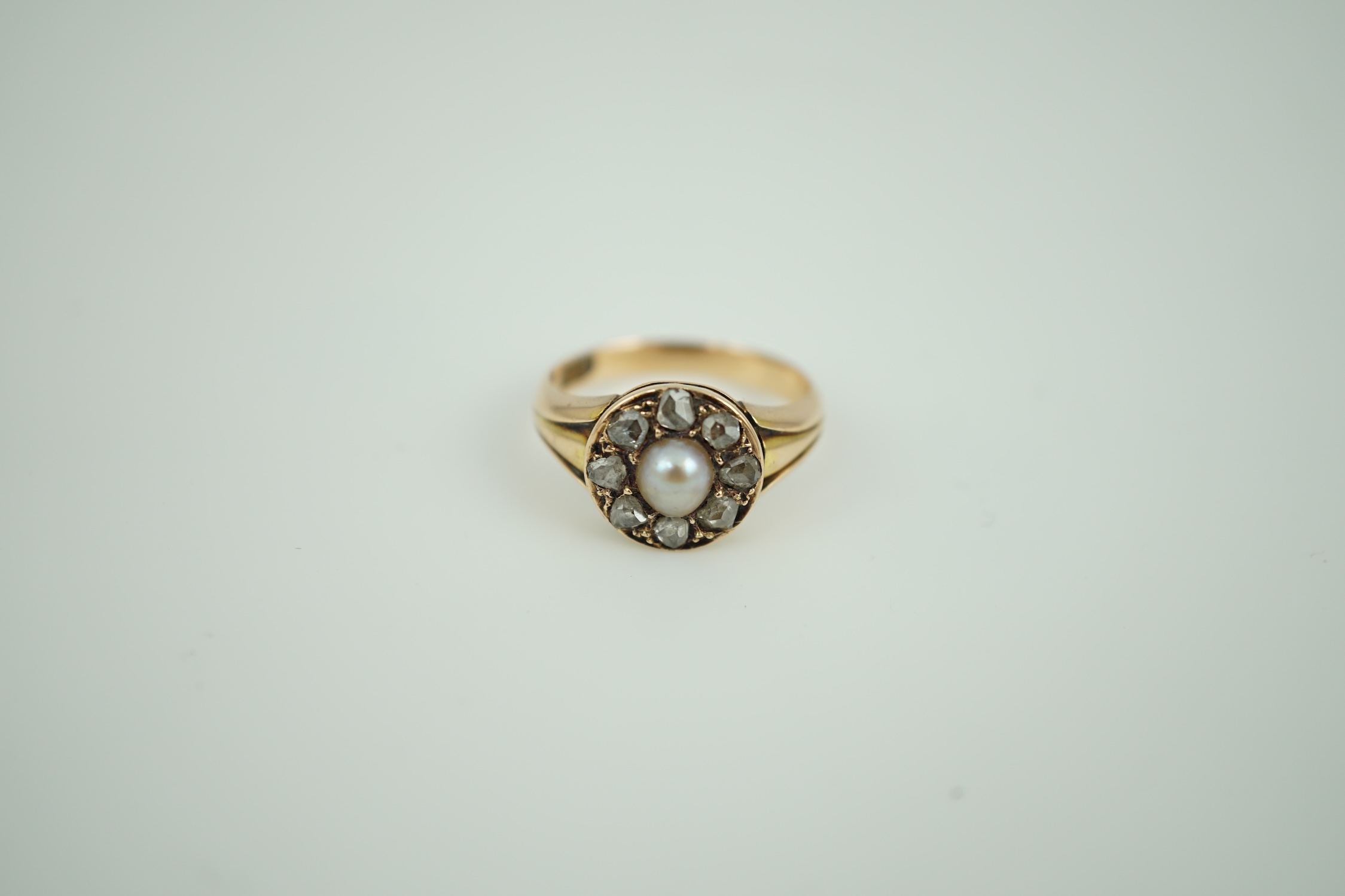 A Victorian 15ct gold, spilt pearl and rose cut diamond set circular cluster ring, size L, gross weight 4.4 grams.